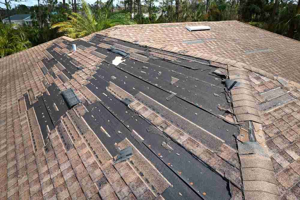 Wind,Damaged,House,Roof,With,Missing,Asphalt,Shingles,After,Hurricane